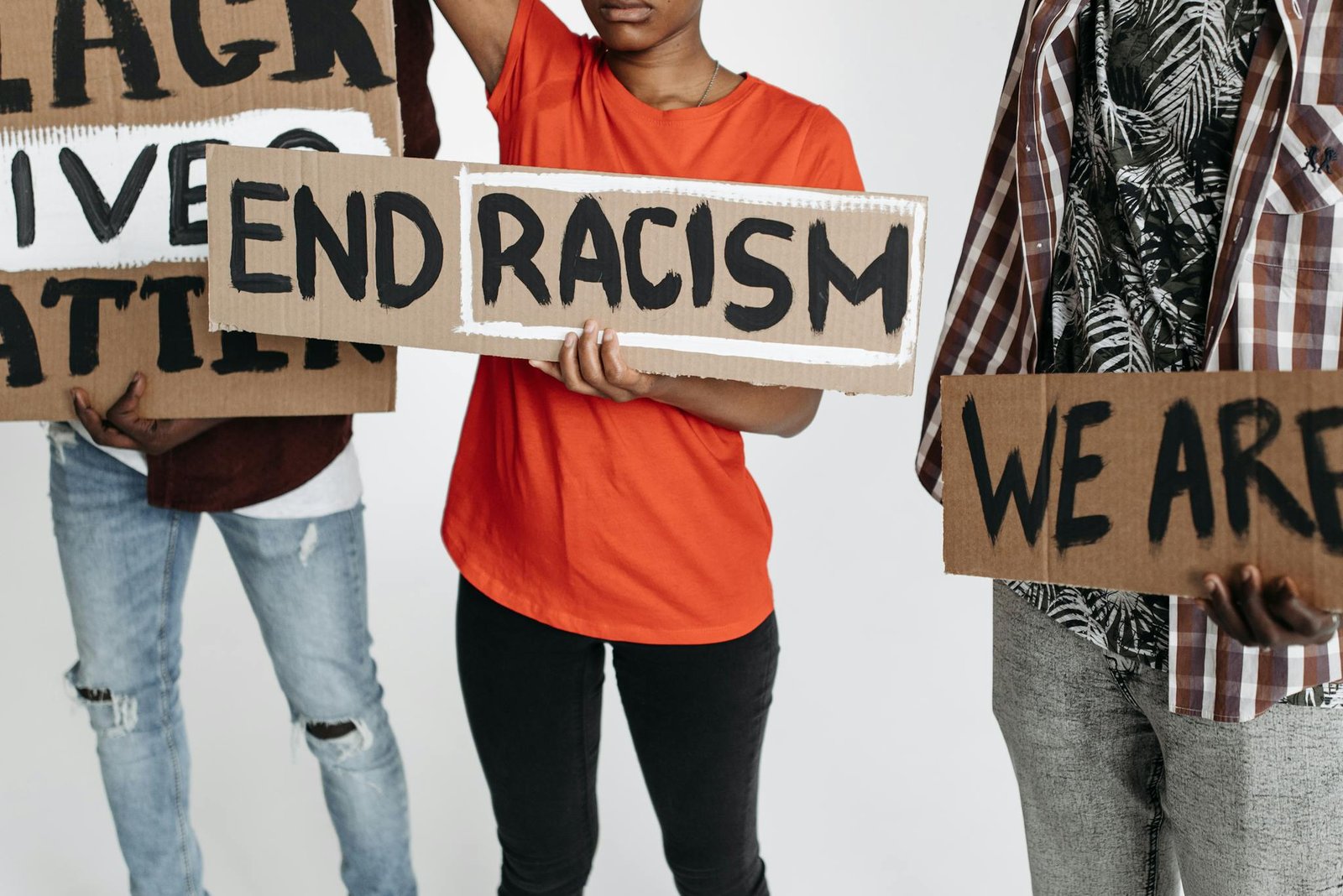 Activists holding signs with messages against racism in a peaceful protest.