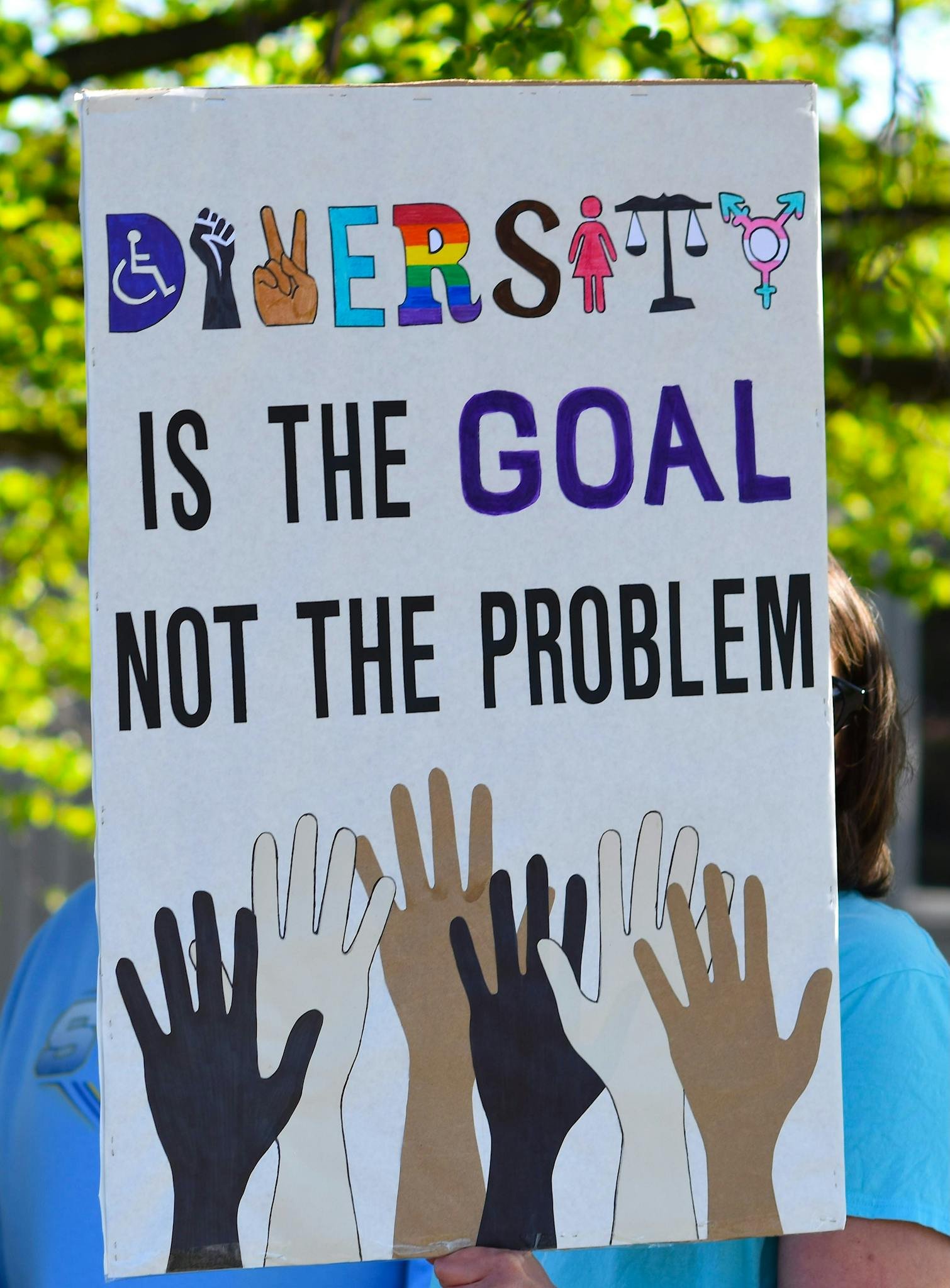 Colorful diversity sign promoting equality and inclusion, featuring hands and equality symbols.